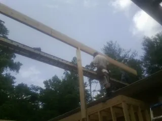 Carpenter setting a ridge beam over a new addition frame — Ice Dam Removal by Roofing Brothers in Tahlequah