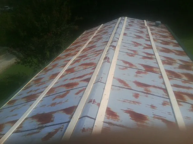 Rusted metal roof panels with new wood purlins before replacement — Storm Damage Roof Repair in Tahlequah by Roofing Brothers